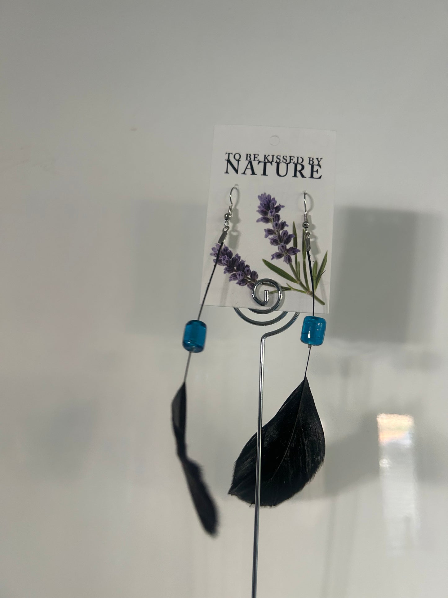 Black feather earrings with blue glass bead